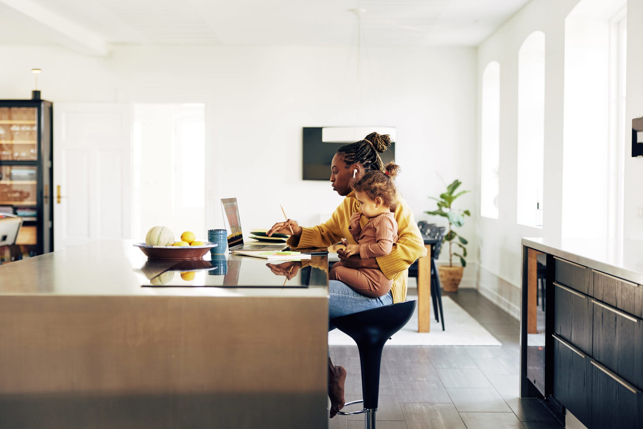 N Pic WFH Mother Working Kitchen Island Laptop Holding Daughter